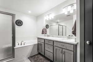 Double vanity with undermount sinks, stone countertop, and contemporary lighting fixtures