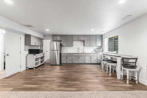 Kitchenette featuring gray shaker-style cabinetry, a subway tile backsplash, and stainless steel appliances