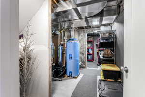 Utility room featuring exposed ductwork, concrete flooring, and ample storage shelving