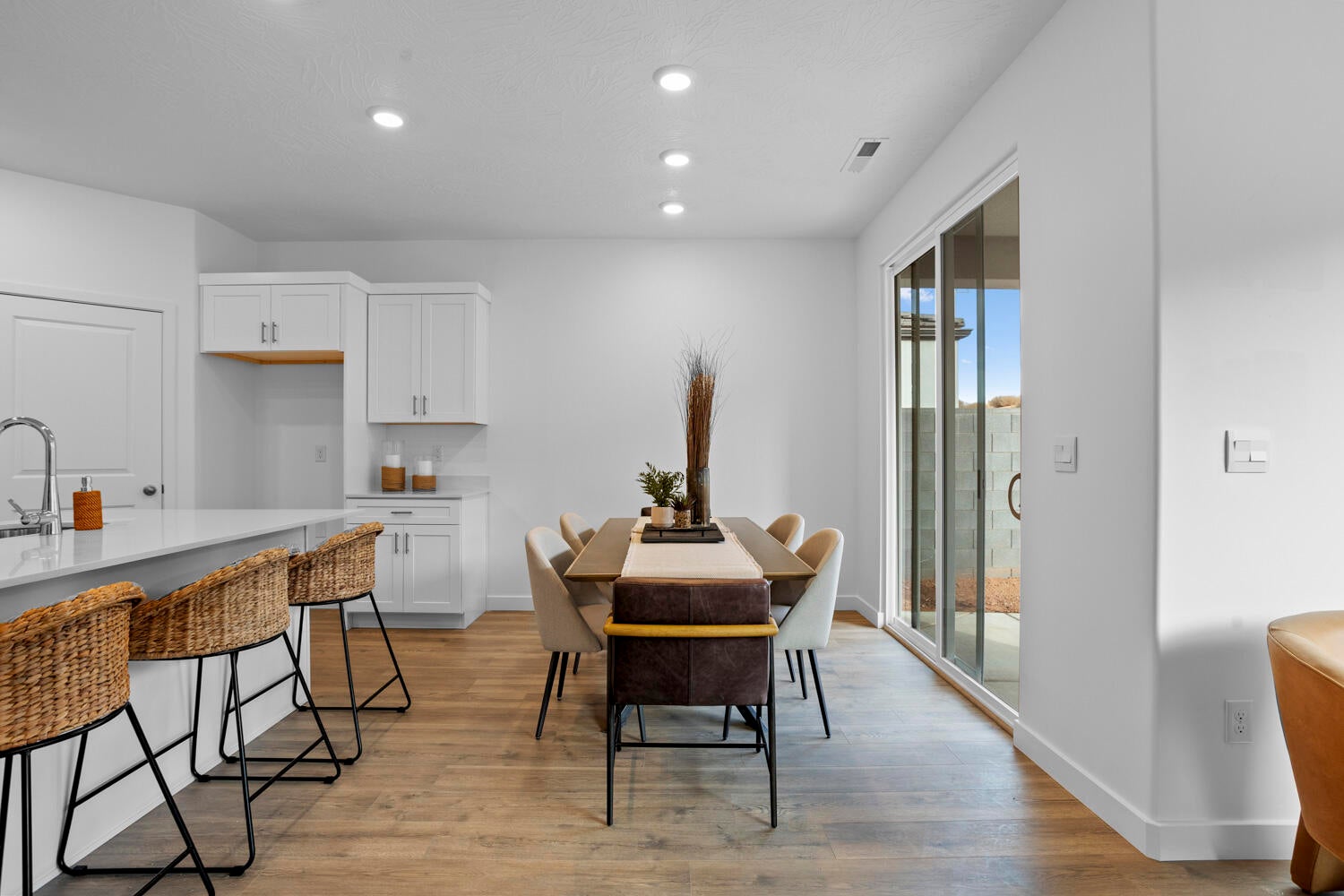 Open-concept living space featuring wood-finish flooring, recessed lighting, and a sliding glass door