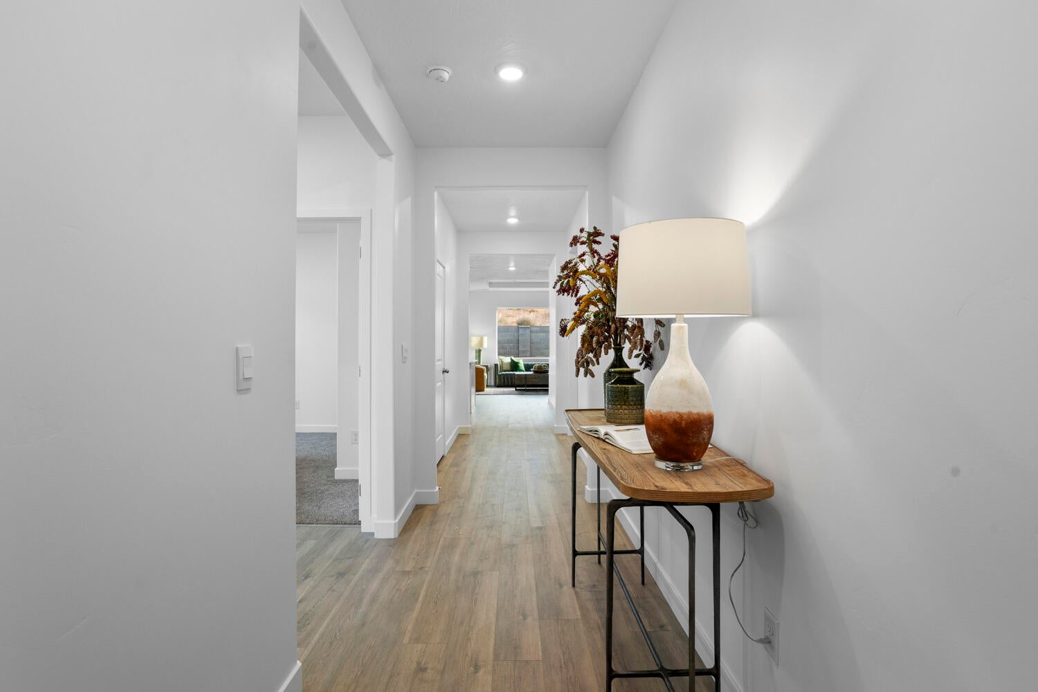 Hardwood-finish flooring extending through a brightly lit hallway