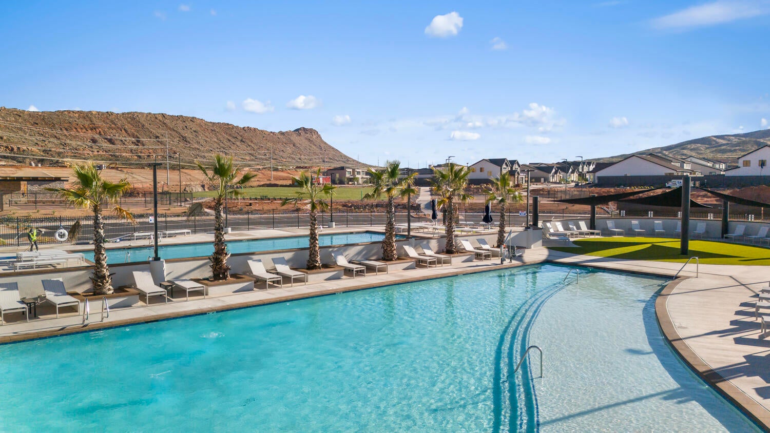 Expansive community pool featuring a lazy river, multiple swimming areas, and a surrounding pool deck