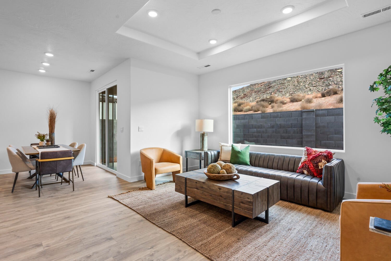 Open-concept living space with wood-finish flooring, a tray ceiling, and recessed lighting