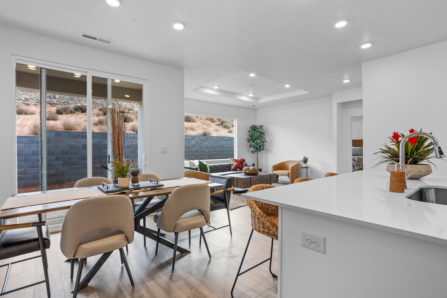 Open-concept living area featuring wood-finish flooring, recessed lighting, and a tray ceiling
