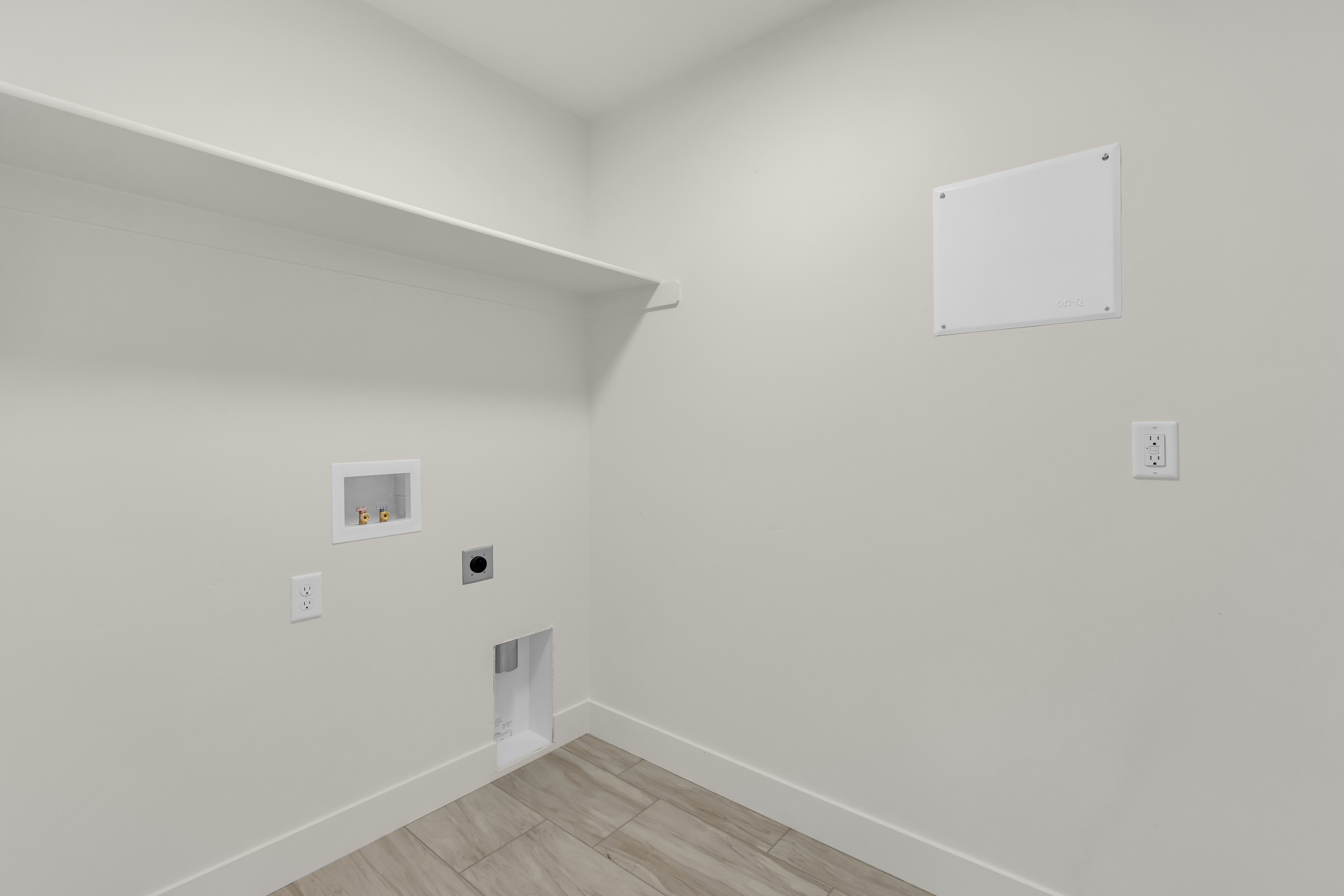Utility room featuring a built-in shelf, appliance hookups, and wood-finish flooring