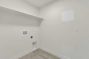 Utility room featuring a built-in shelf, appliance hookups, and wood-finish flooring