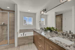 Spacious bathroom featuring a dual vanity with granite countertops, wood-finish cabinetry, and brushed nickel fixtures