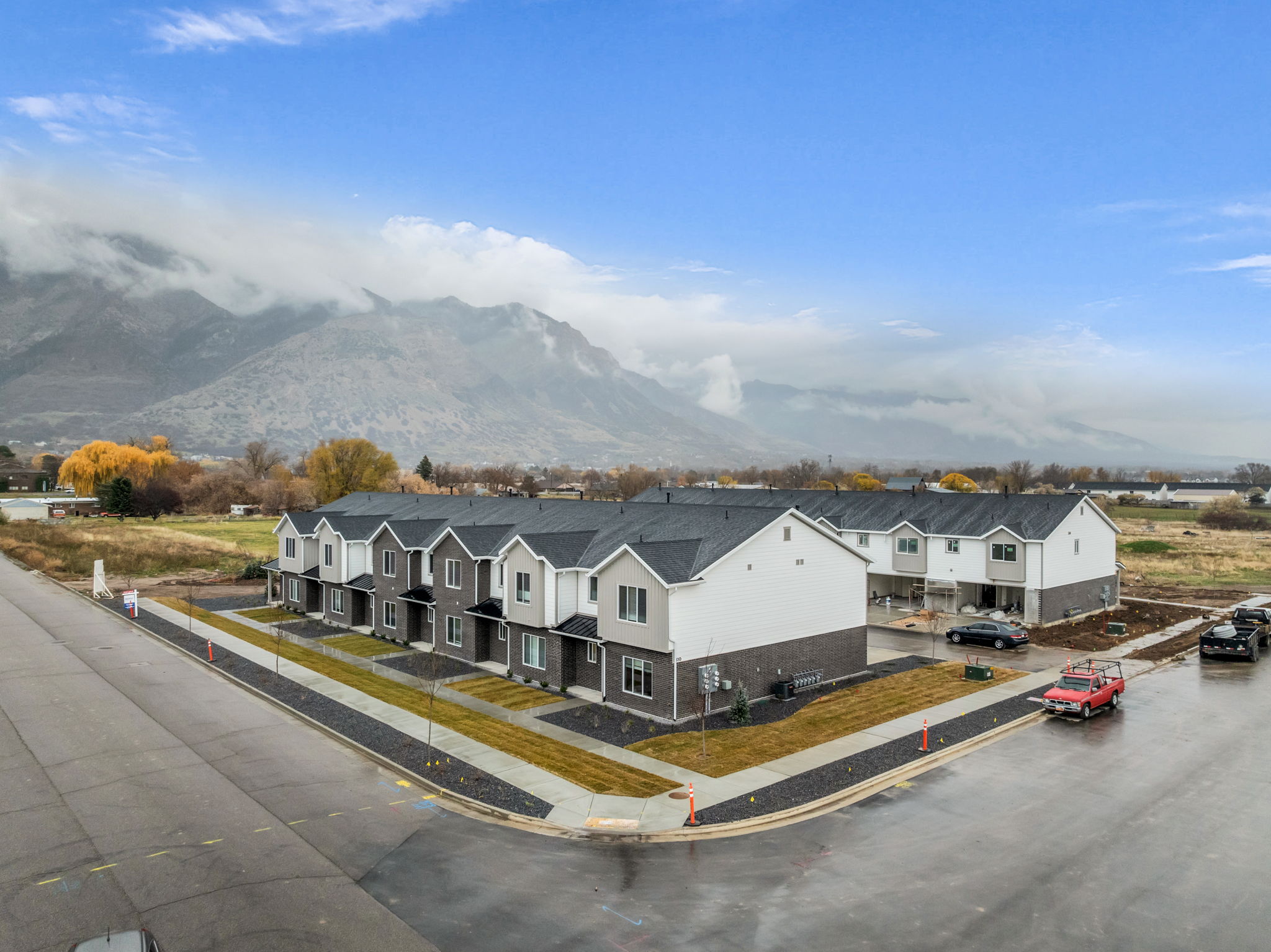 Modern townhome community featuring contemporary facades, dark asphalt shingle roofs, and light-toned siding