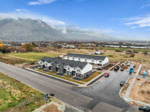 Newly constructed townhomes featuring multi-tone siding, dark shingle roofing, and individual paved driveways