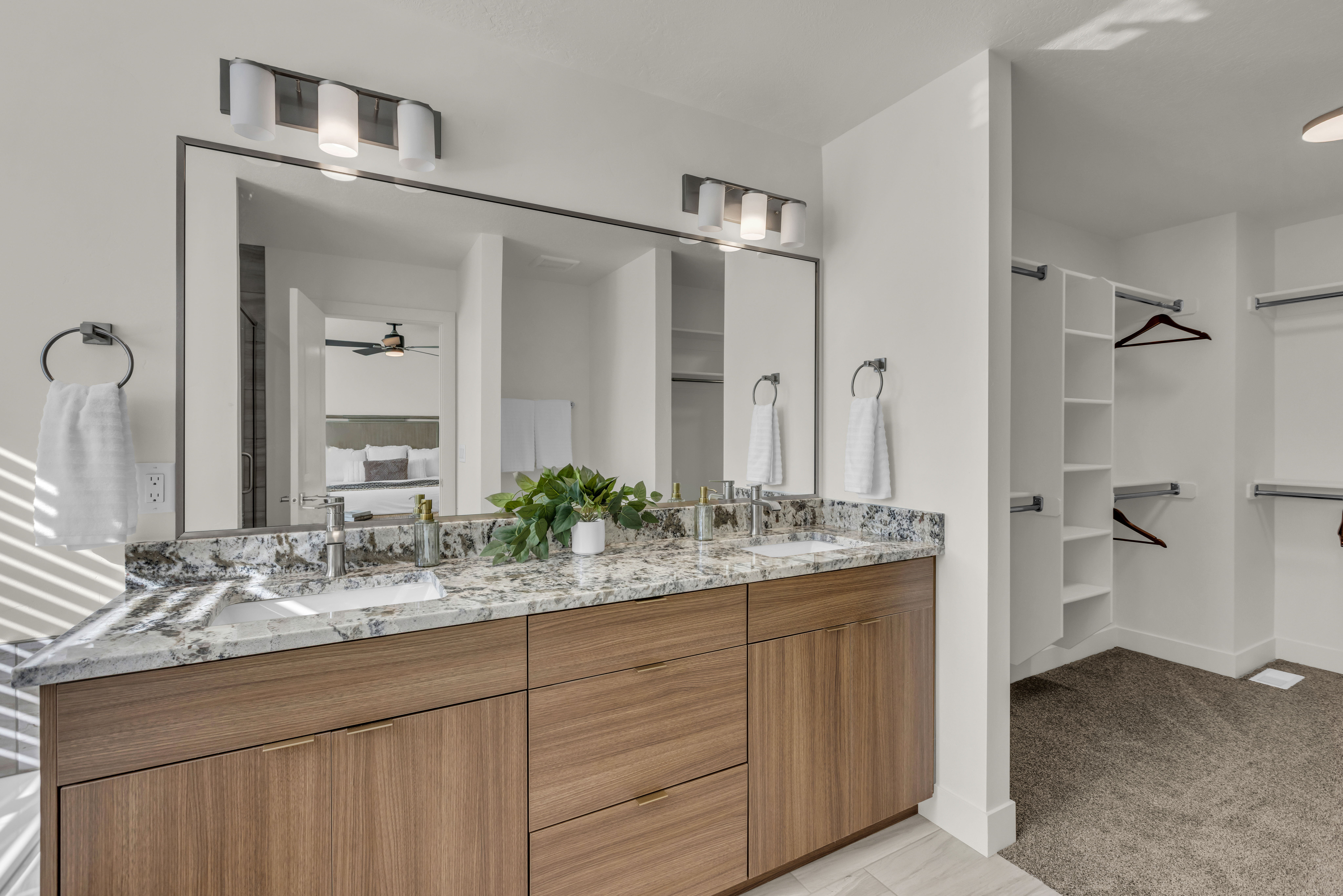 Dual vanity with stone countertop and wood-finish cabinetry