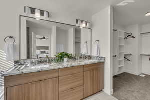 Dual vanity with stone countertop and wood-finish cabinetry