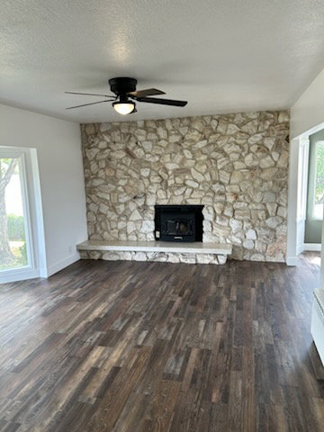 Living area featuring a floor-to-ceiling stone fireplace with an integrated firebox and hearth