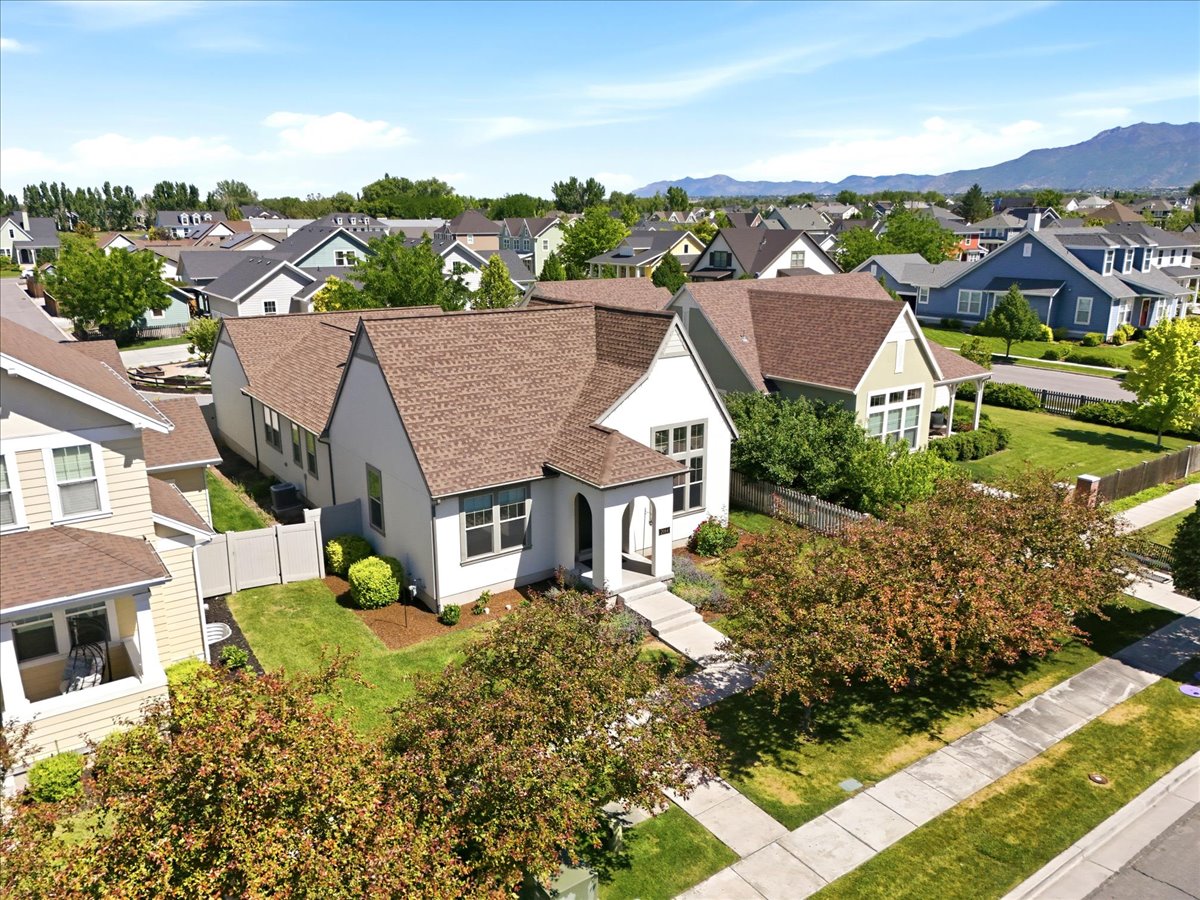 Contemporary two-story residence featuring a light-toned facade, gabled rooflines, and a paved front walkway