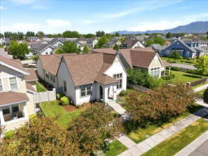 Contemporary two-story residence featuring a light-toned facade, gabled rooflines, and a paved front walkway