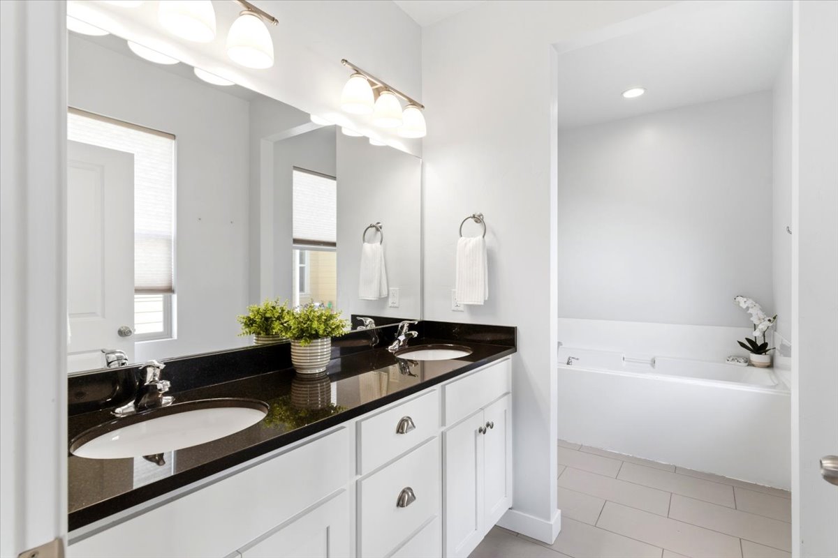 Primary bathroom with dual vanity, granite countertop