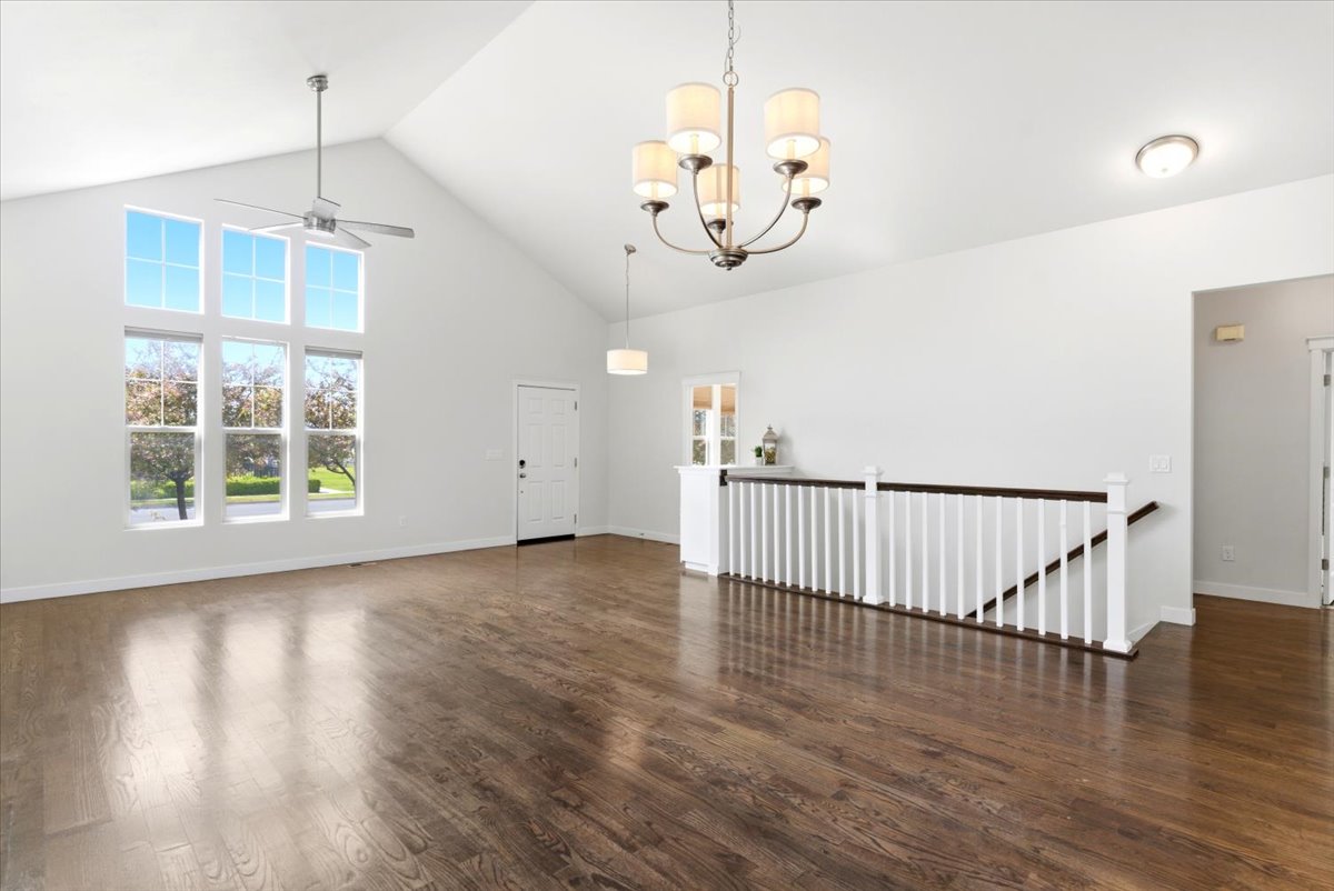 Spacious interior featuring a vaulted ceiling and wood-finish flooring