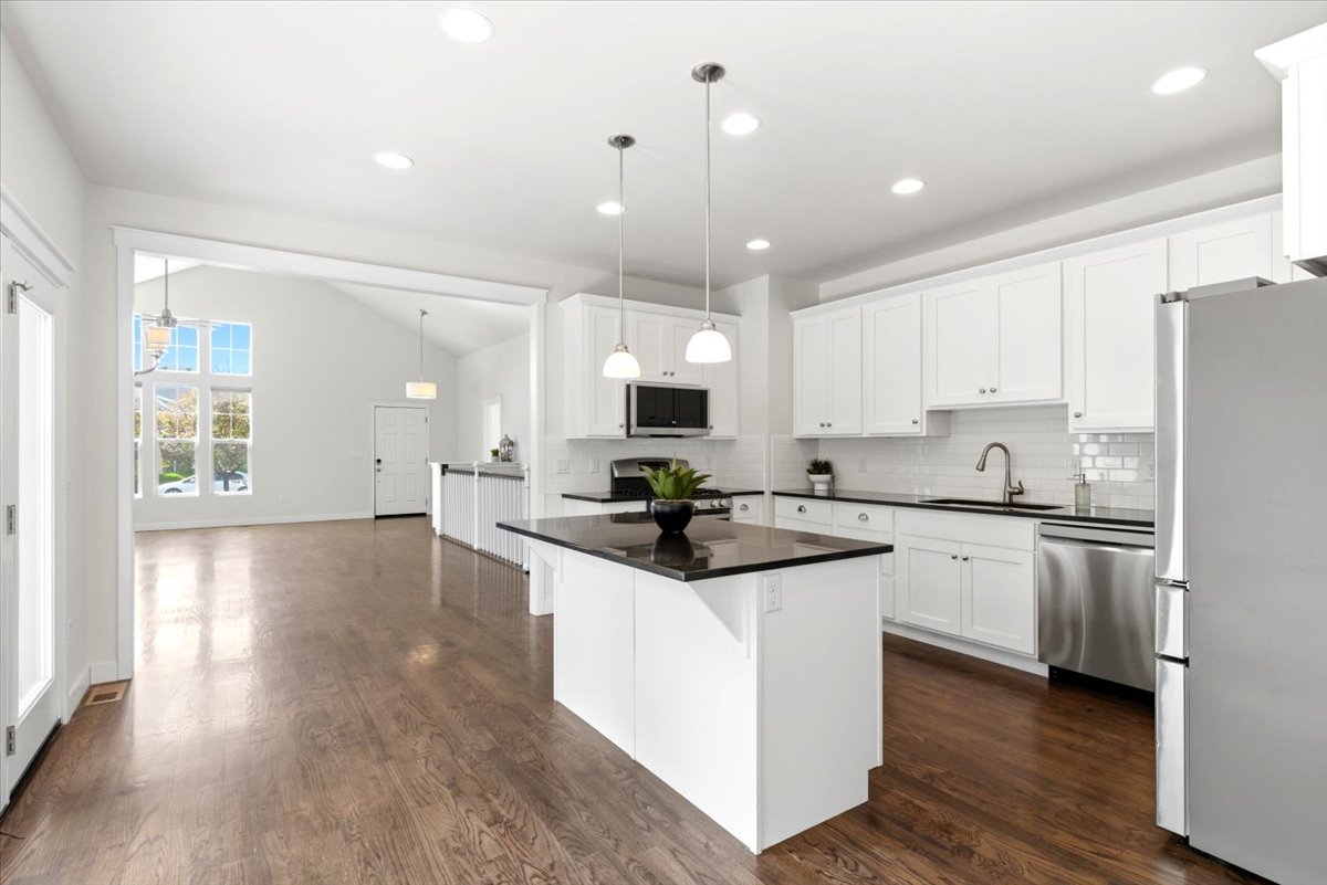 Modern kitchen featuring white cabinetry, granite countertops, and stainless steel appliances