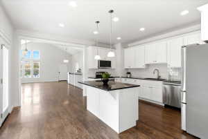 Modern kitchen featuring white cabinetry, granite countertops, and stainless steel appliances