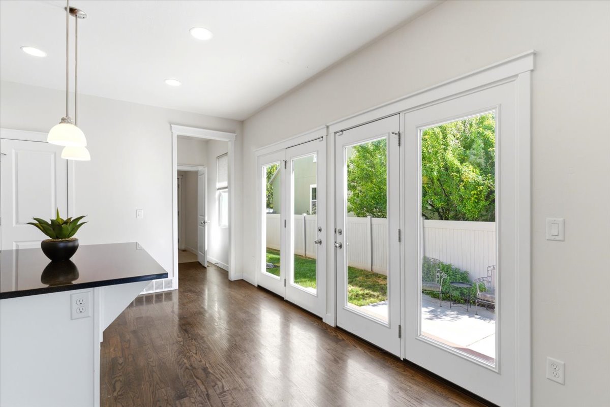 Hardwood flooring, complemented by recessed ceiling lighting and a kitchen island with a granite countertop