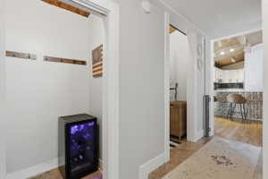 Recessed alcove with built-in wine refrigerator and wooden coat hooks