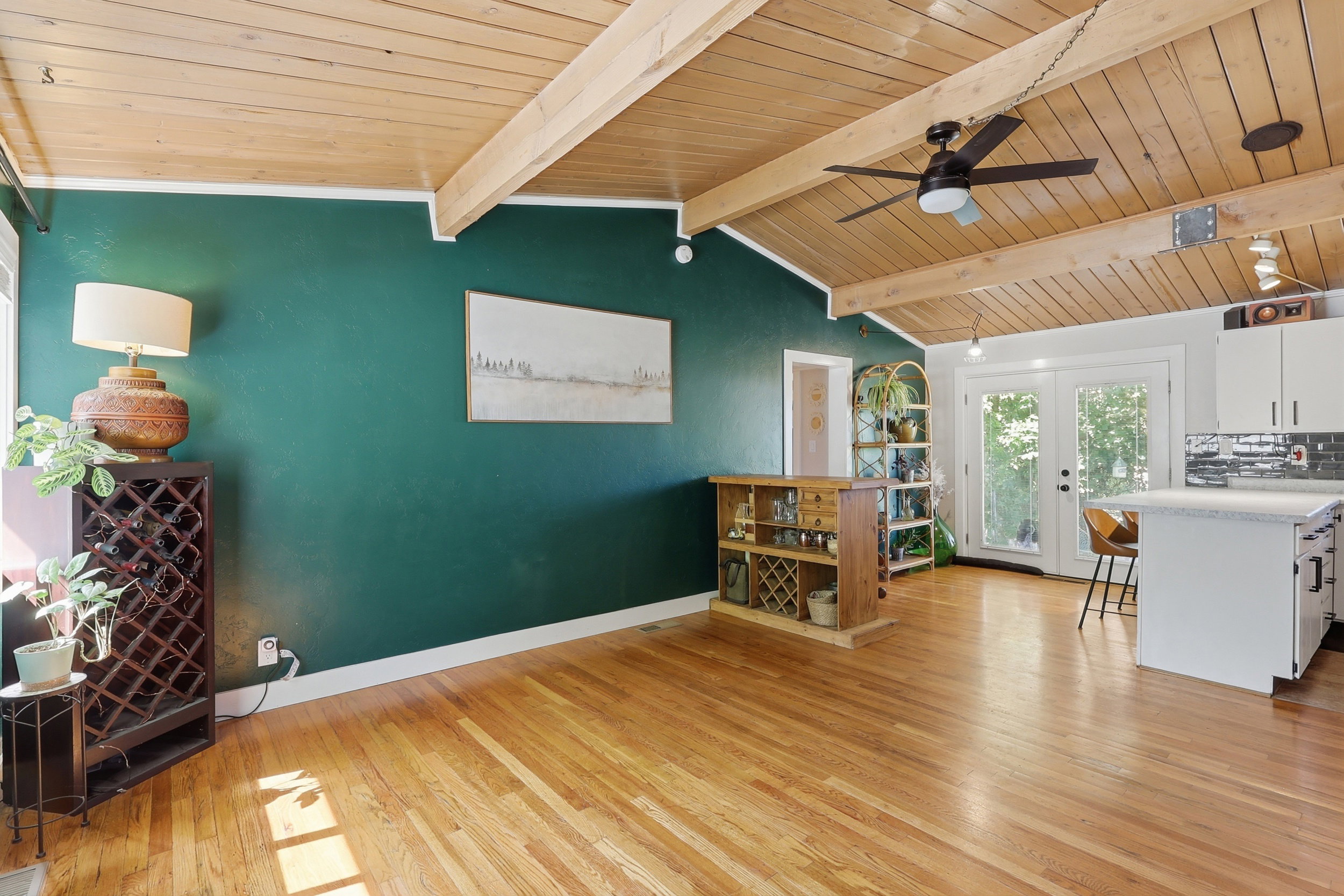 Open concept living area featuring vaulted wood-plank ceilings with exposed beams, wood-finish flooring, and a built-in kitchen island