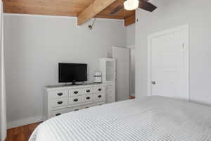 Vaulted wood-finish ceiling with exposed beams and a ceiling fan