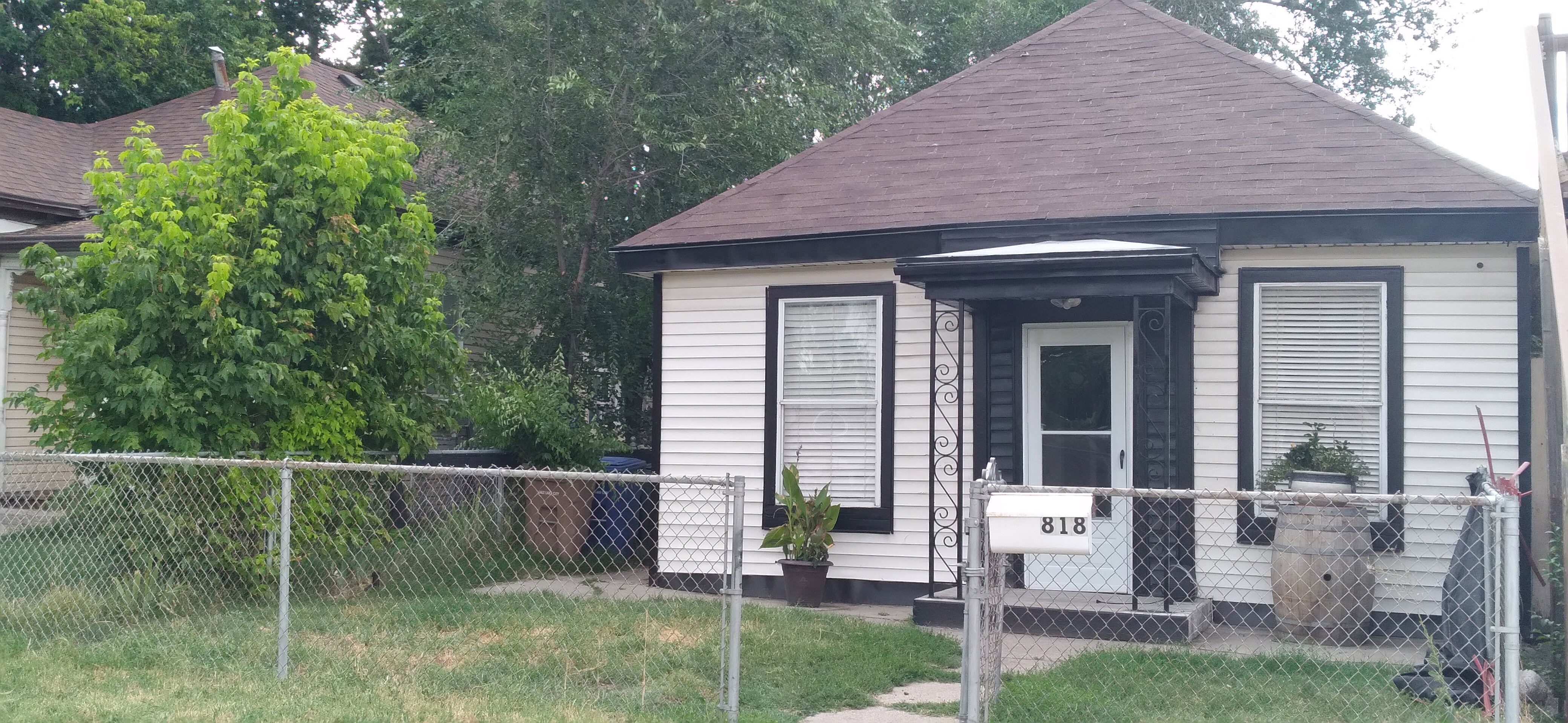 White siding exterior with a dark shingle roof and contrasting dark trim