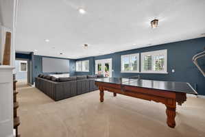 Spacious recreation room featuring recessed lighting, a large projection screen, and durable carpeting