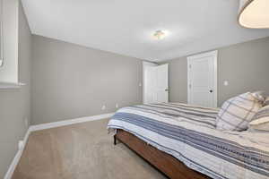 Carpeted room featuring light gray walls, white baseboards, and a window with a white sill