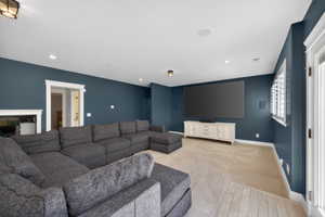 Entertainment space featuring dark blue painted walls, recessed lighting, white trim, and a large display screen mounted above a white credenza