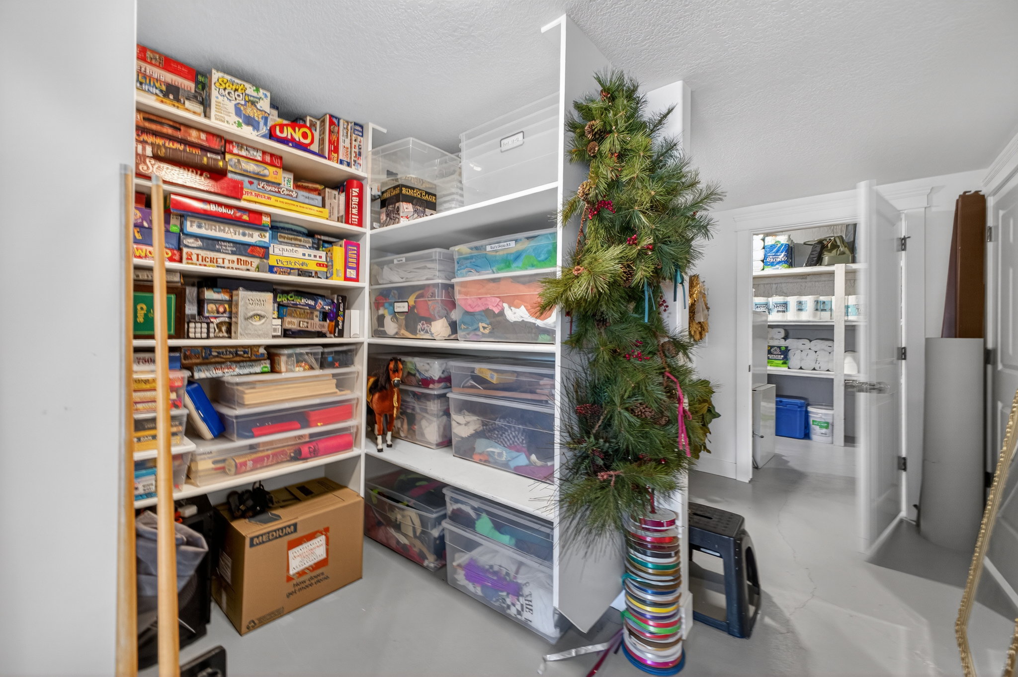 Built-in shelving system with white finishes, offering extensive storage capacity within a dedicated area