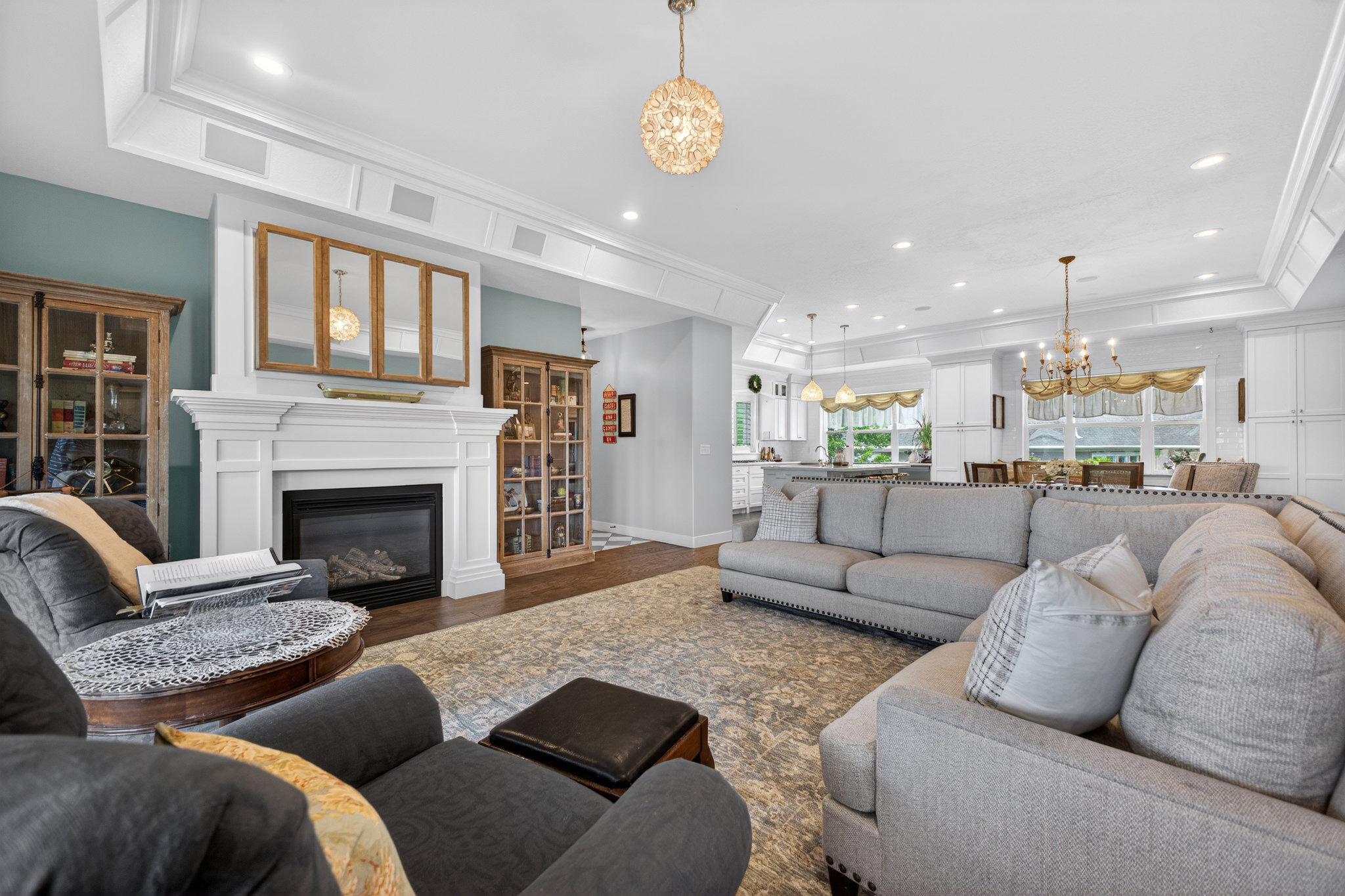 Living space featuring a white mantel fireplace with a gas insert, complemented by built-in ceiling speakers