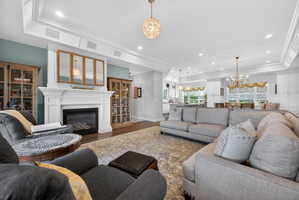 Living space featuring a white mantel fireplace with a gas insert, complemented by built-in ceiling speakers