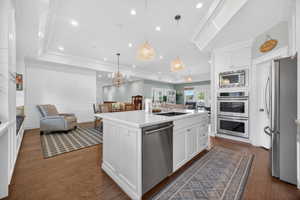 White kitchen island with a built-in sink and stainless steel dishwasher