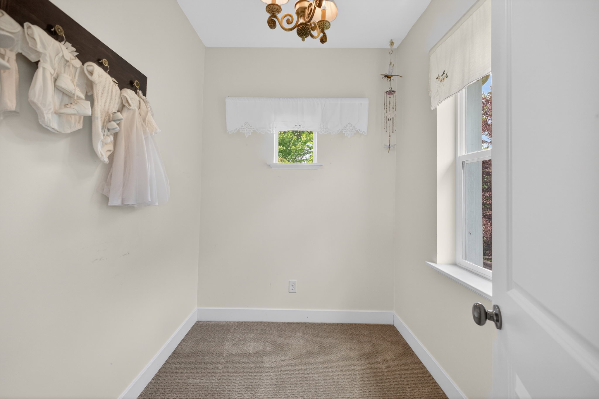 Compact room featuring two windows, neutral wall tones, and a single ceiling fixture
