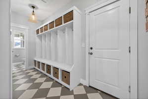 Custom built-in mudroom bench with cubbies and woven baskets provides ample storage