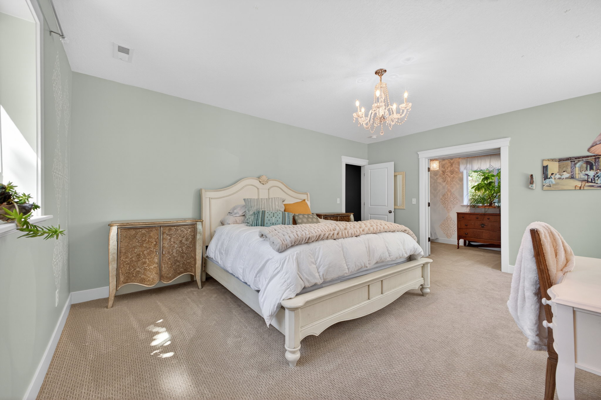 Spacious bedroom featuring light neutral wall tones and plush carpeting