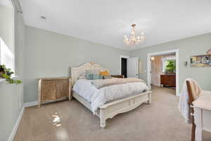 Spacious bedroom featuring light neutral wall tones and plush carpeting