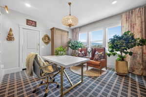 Light-filled room featuring multiple windows with mountain scenery, a decorative chandelier, recessed lighting, and a patterned floor covering