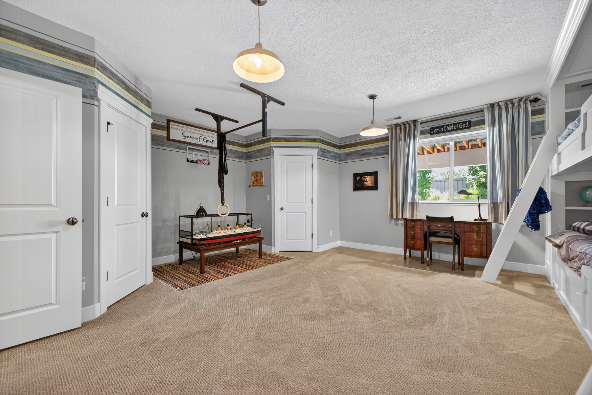 Spacious room featuring neutral carpeting and light gray walls with a decorative border