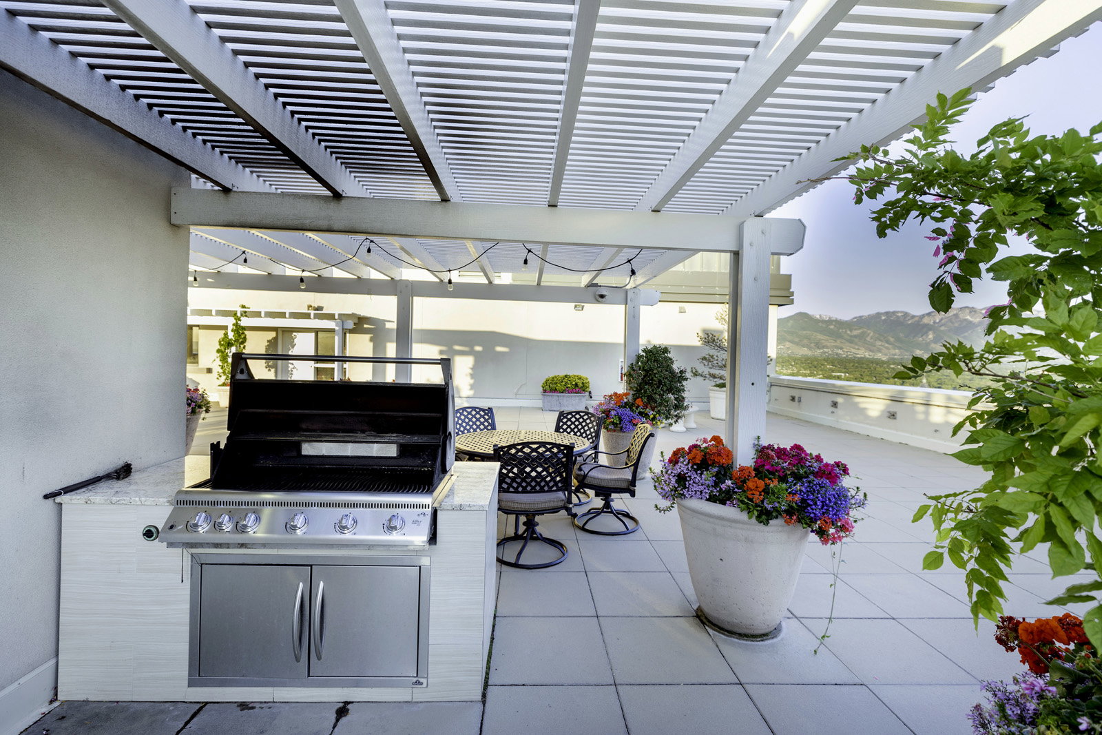 Expansive outdoor patio featuring an integrated built-in grill with stainless steel cabinetry