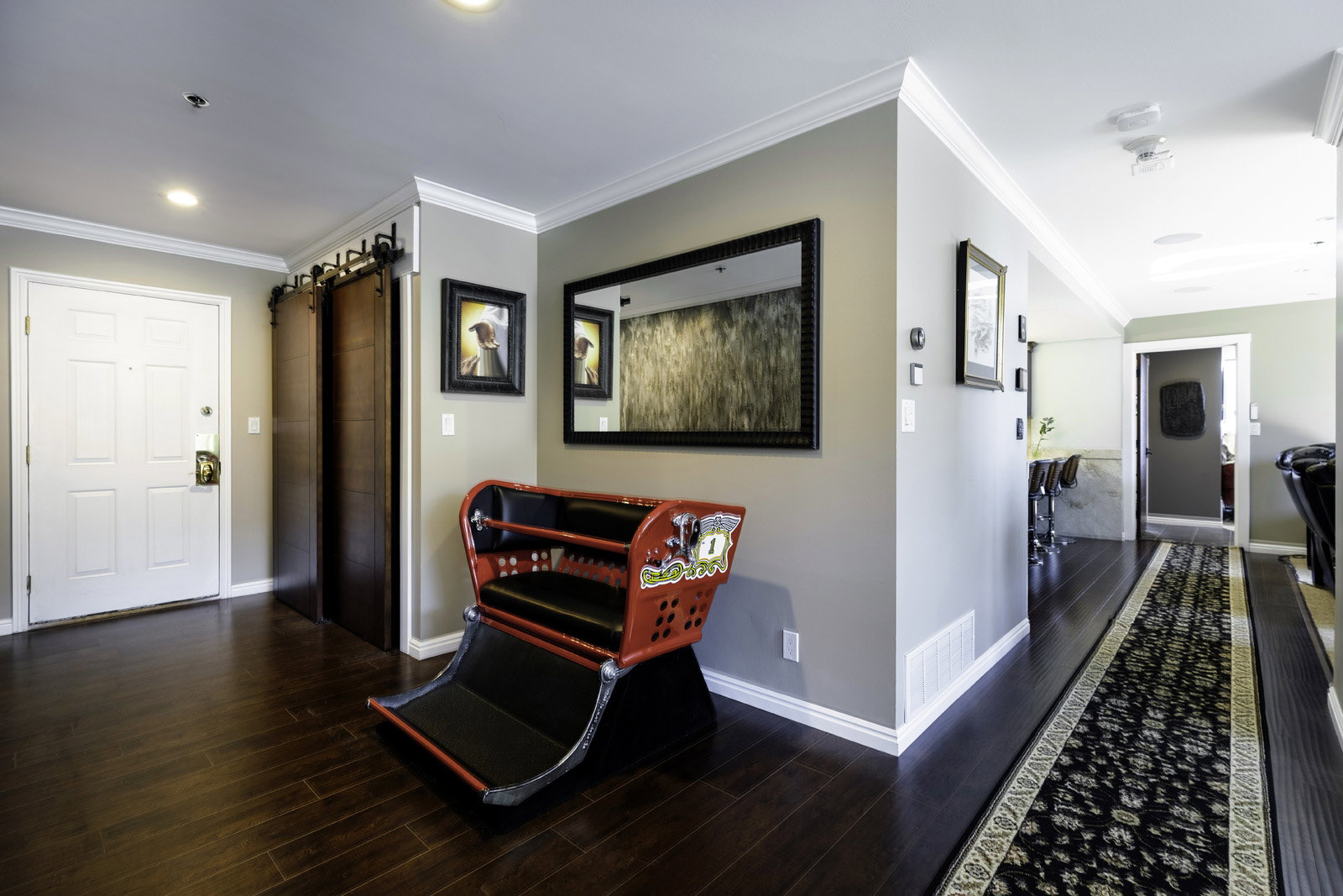 Entryway featuring dark wood-finish flooring, a white paneled entry door, and a barn door system