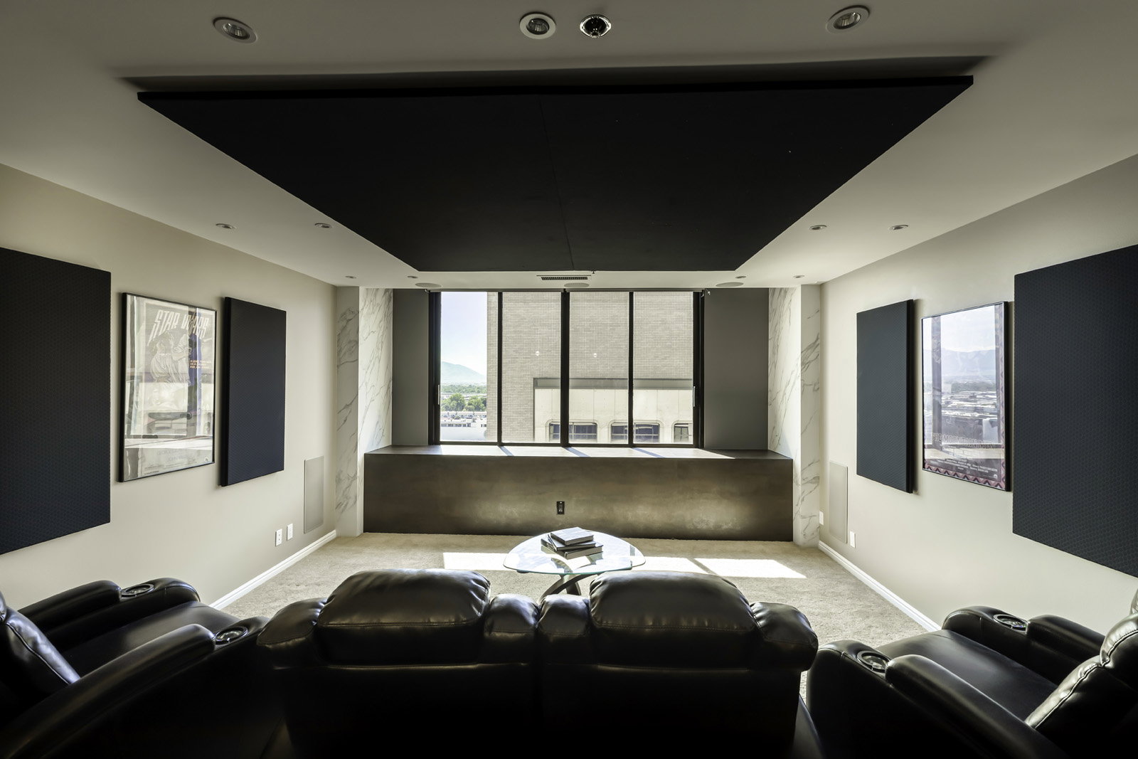 Dedicated media room featuring a large, dark ceiling panel and recessed lighting