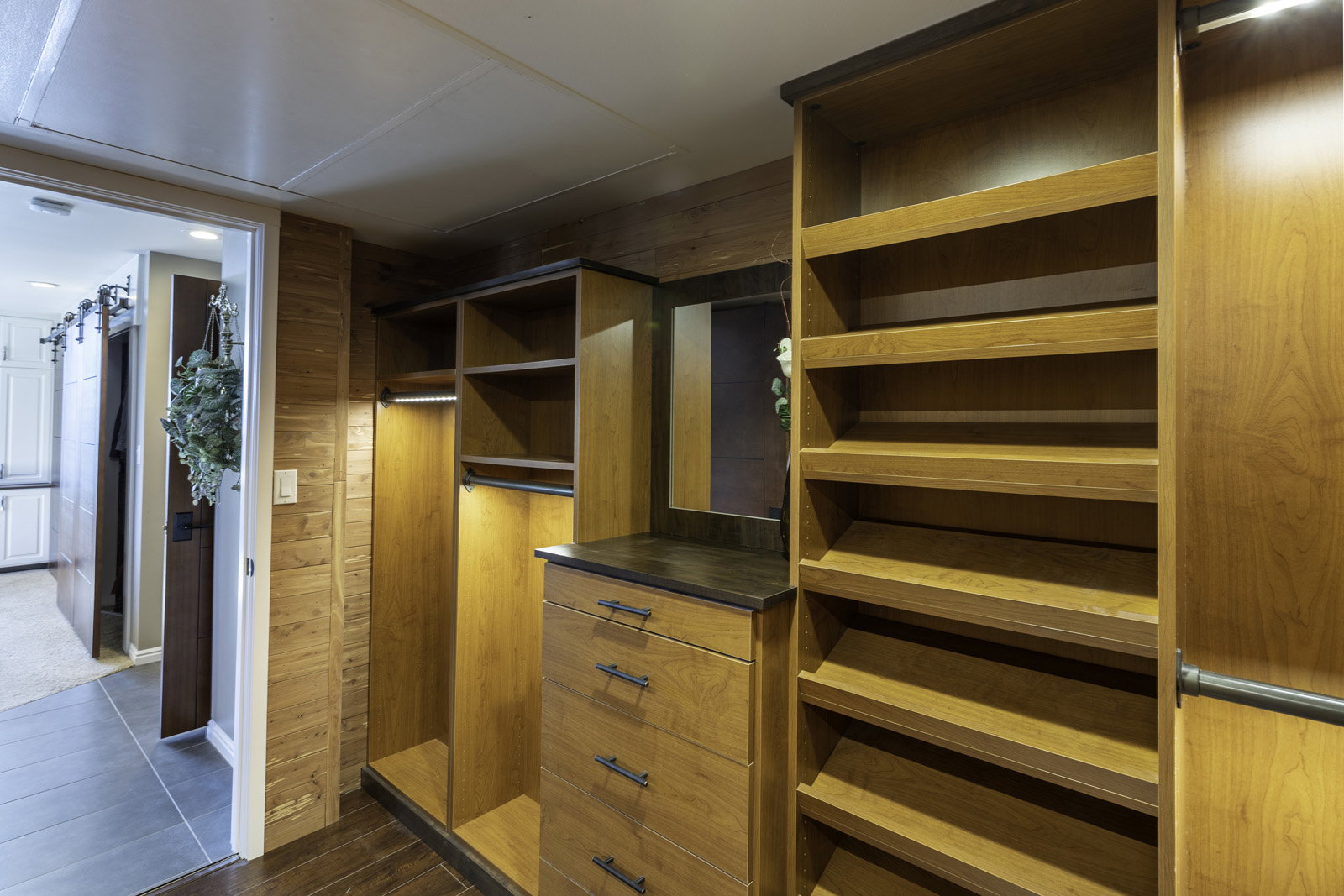 Custom wood cabinetry featuring integrated shelving, drawers, and hanging rods