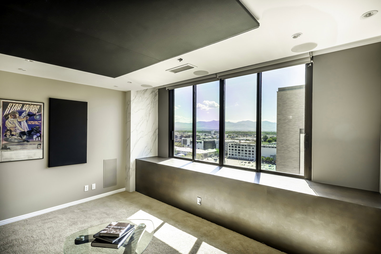 Floor-to-ceiling windows with roller shades, a built-in window bench, a recessed ceiling panel, recessed lighting, and integrated ceiling speakers