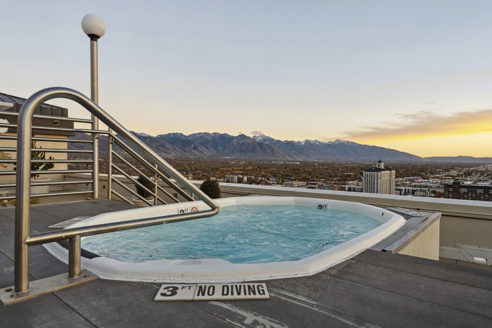 Rooftop spa featuring a stainless steel handrail and surrounding composite decking