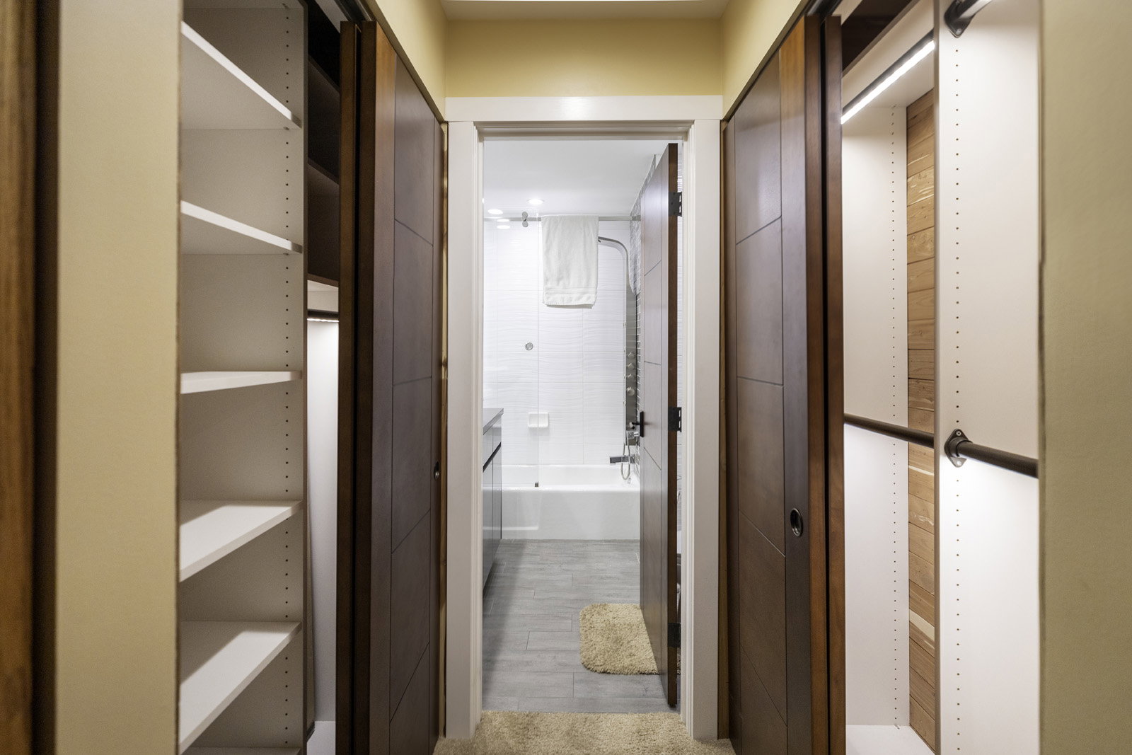 Hallway featuring dual sliding wood-paneled doors on overhead tracks
