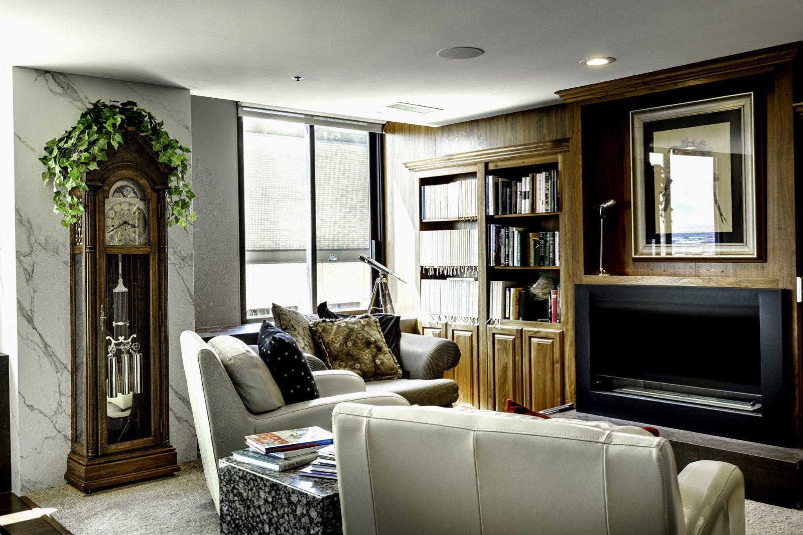 Living area featuring a floor-to-ceiling window, recessed ceiling lighting, a built-in wood-paneled entertainment center with shelving and an integrated fireplace, and a light-colored carpet