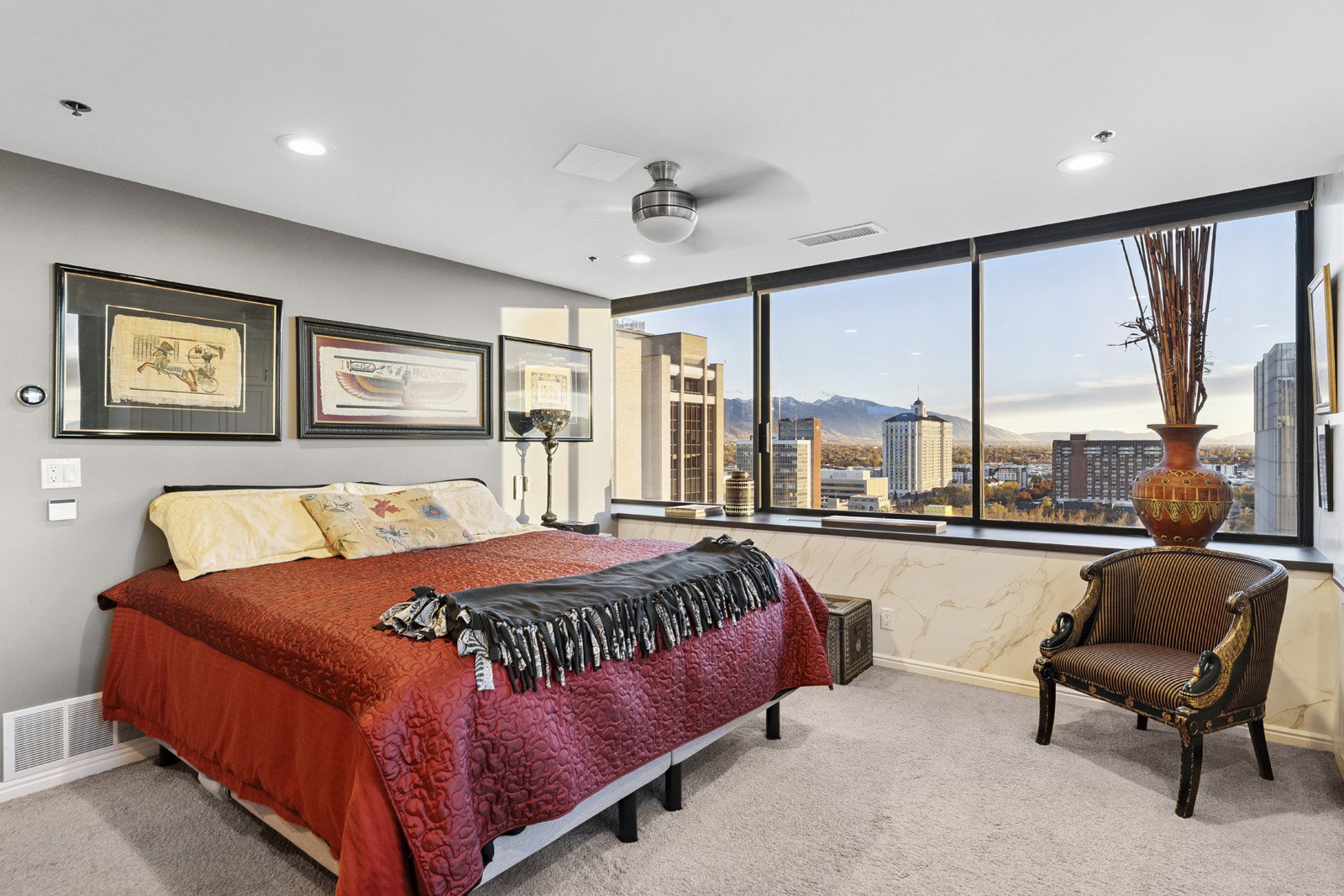 Expansive window wall offering city and mountain scenery