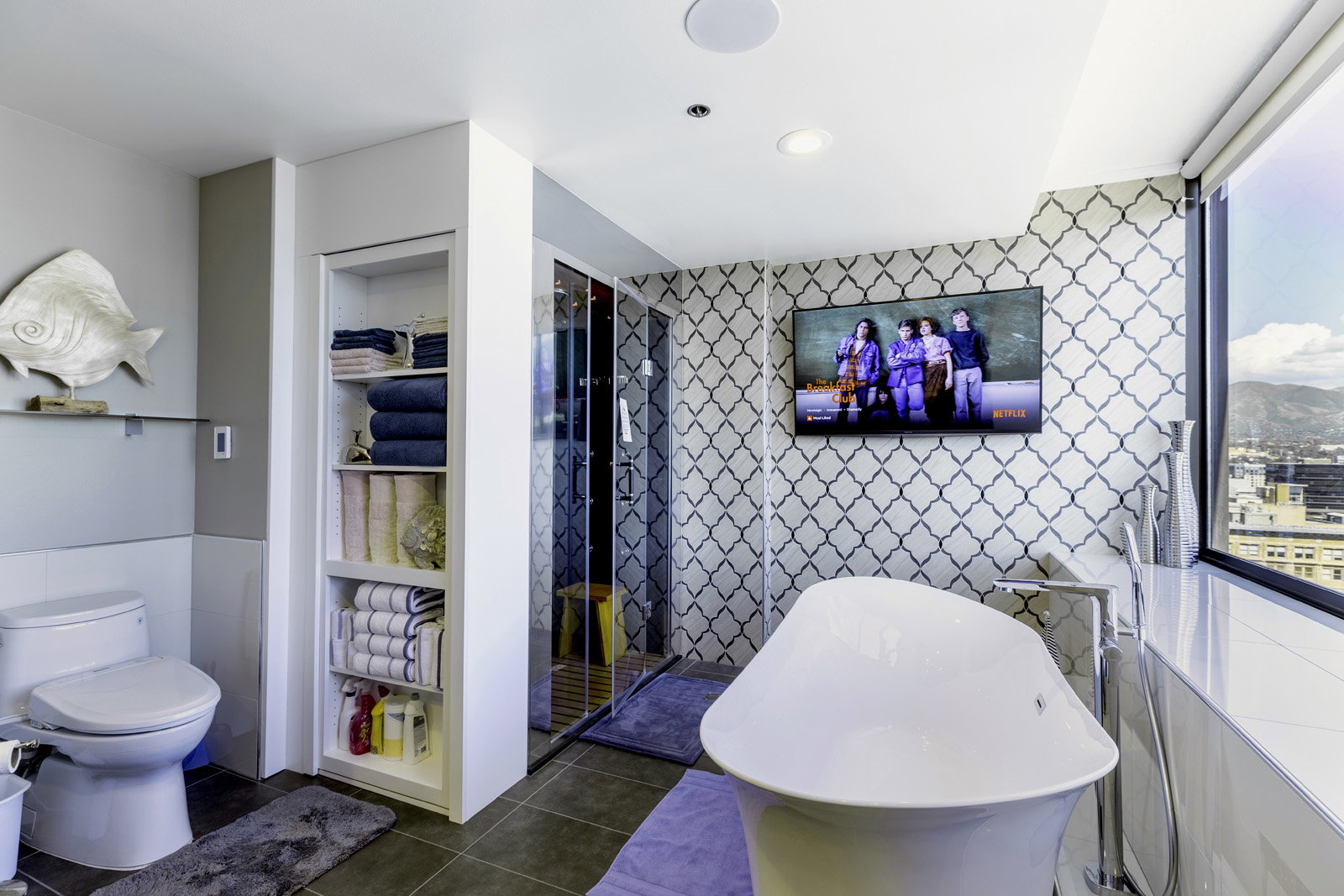Freestanding soaking tub with floor-mounted faucet, complemented by patterned accent wall